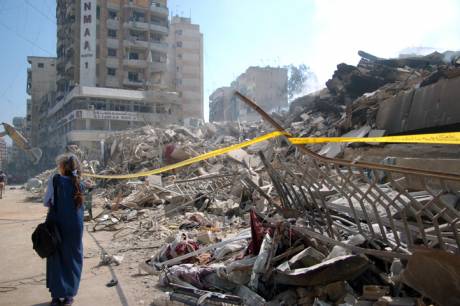 Kathy Kelly walks through rubble