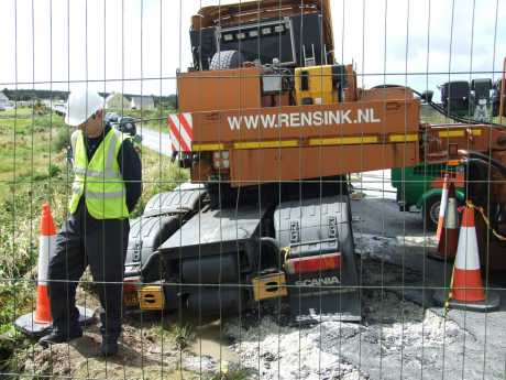 Truck in ditch with ripped up road