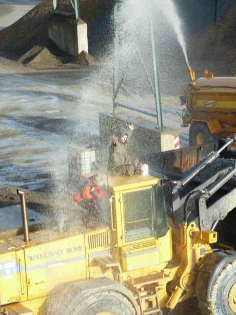 Campaigners being water cannoned on top of the digger and truck