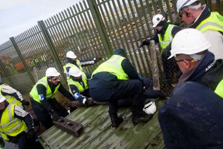 Click on image to see full-sized version people being forcably removed from fence panels